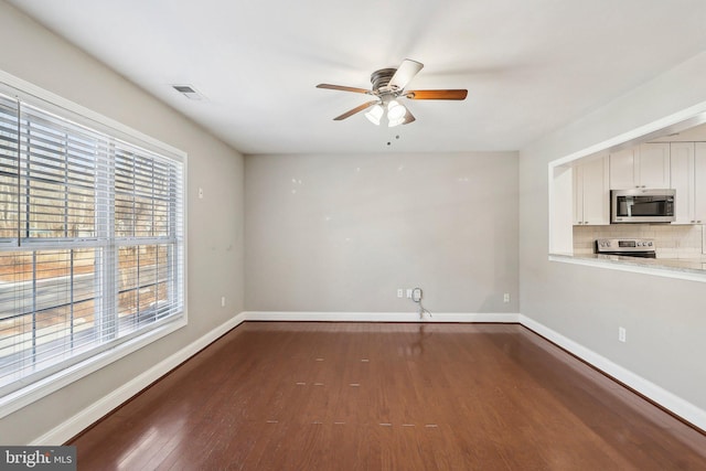 spare room featuring dark wood-type flooring and ceiling fan