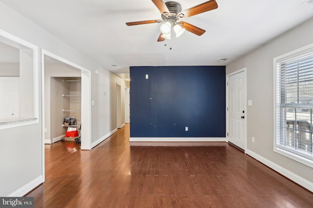 empty room with dark wood-type flooring and ceiling fan