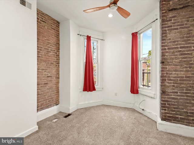 carpeted empty room with a wealth of natural light and ceiling fan