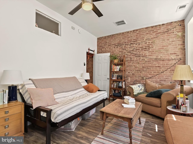 living room with ceiling fan, dark wood-type flooring, and brick wall