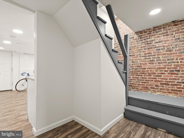 interior space featuring hardwood / wood-style floors and brick wall