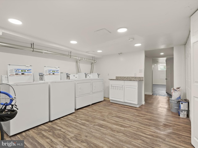 laundry area with light hardwood / wood-style flooring and washing machine and clothes dryer