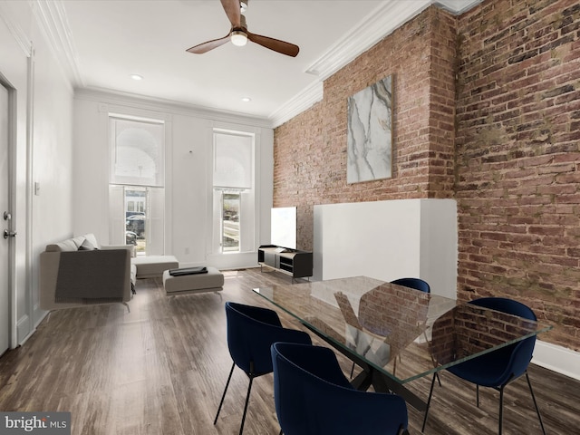 dining space featuring dark hardwood / wood-style flooring, brick wall, and ornamental molding