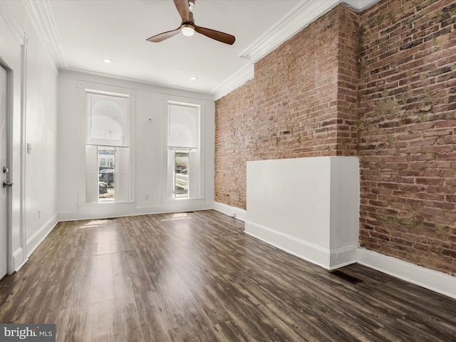 unfurnished living room with ceiling fan, dark hardwood / wood-style flooring, brick wall, and ornamental molding