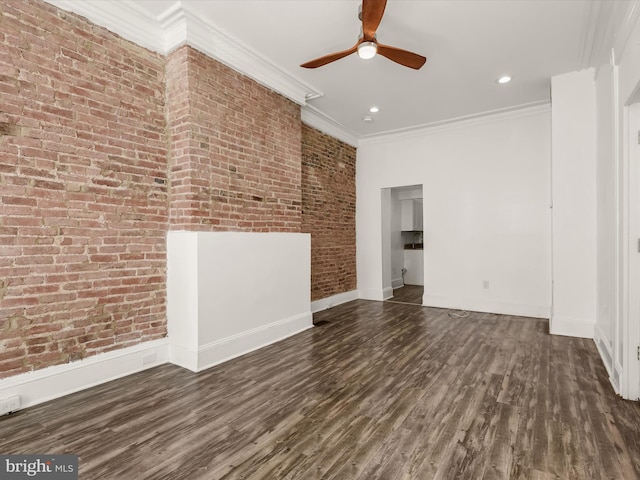 unfurnished room featuring ceiling fan, dark wood-type flooring, brick wall, and ornamental molding