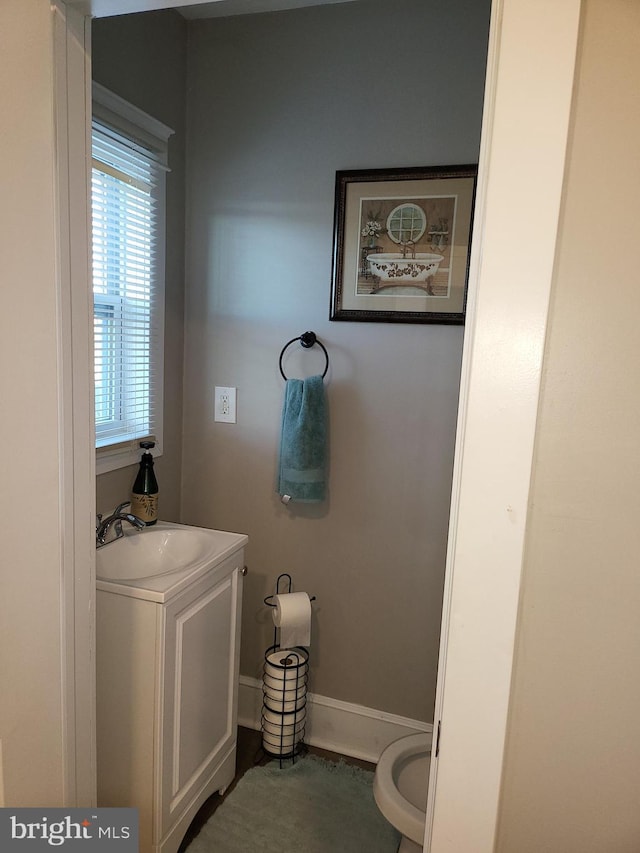 bathroom featuring a wealth of natural light, sink, and toilet