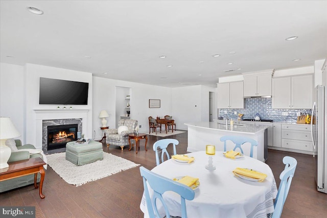 dining space with sink, dark hardwood / wood-style flooring, and a fireplace