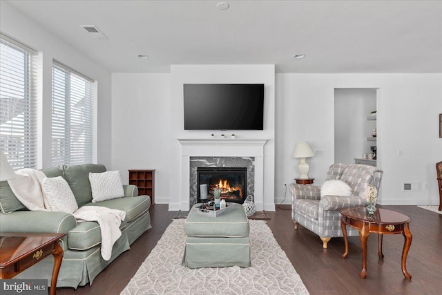 living room featuring a premium fireplace and dark hardwood / wood-style floors