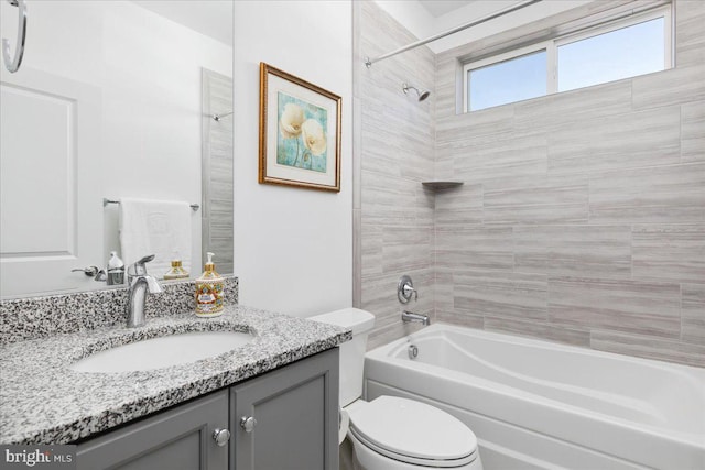 full bathroom with toilet, tiled shower / bath, and vanity