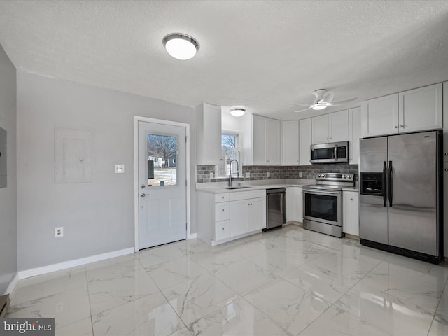 kitchen with sink, white cabinetry, ceiling fan, tasteful backsplash, and appliances with stainless steel finishes