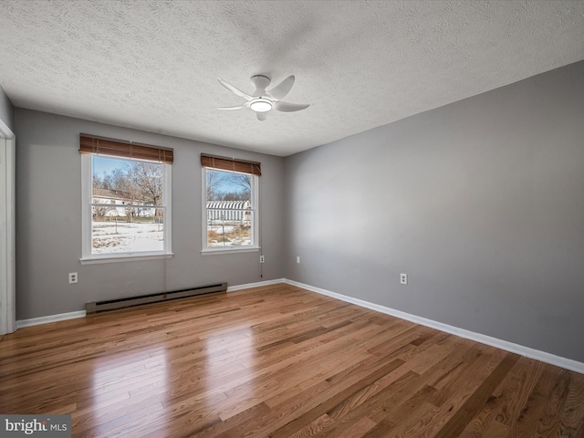 unfurnished room featuring a textured ceiling, ceiling fan, a baseboard radiator, and wood-type flooring