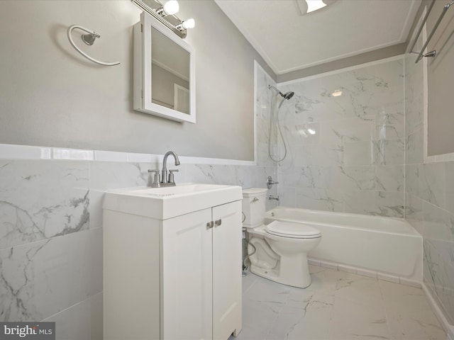 full bathroom featuring toilet, tiled shower / bath, tile walls, and vanity