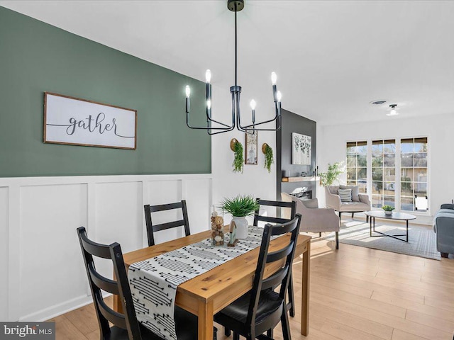 dining area featuring an inviting chandelier and light hardwood / wood-style floors