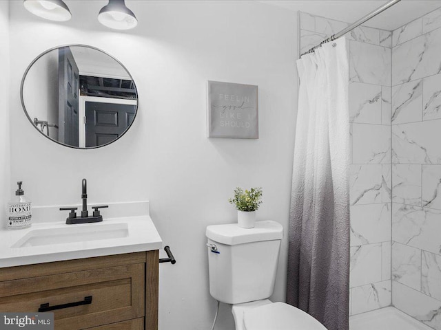 bathroom featuring walk in shower, vanity, and toilet