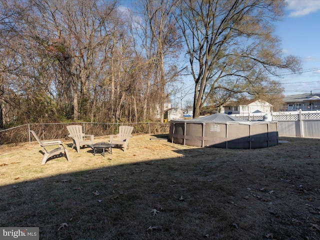 view of yard with a fenced in pool and an outdoor fire pit