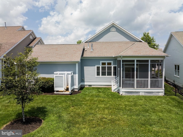 rear view of property featuring a lawn and a sunroom