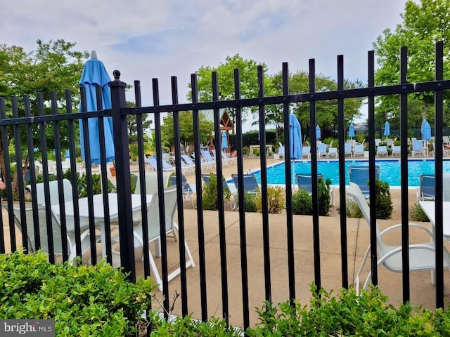 view of gate with a patio and a community pool