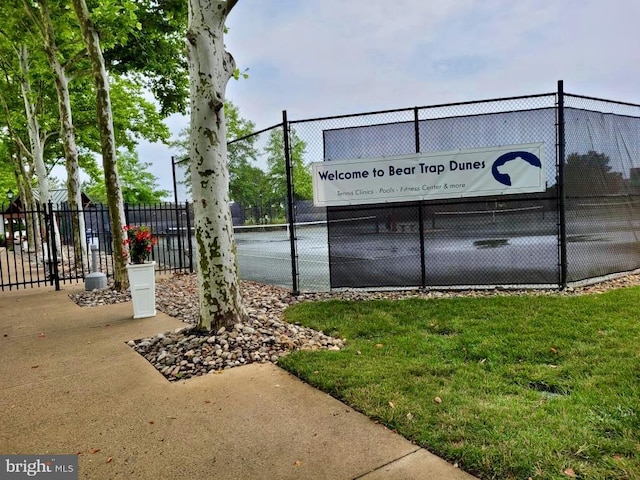 view of home's community featuring a yard and tennis court