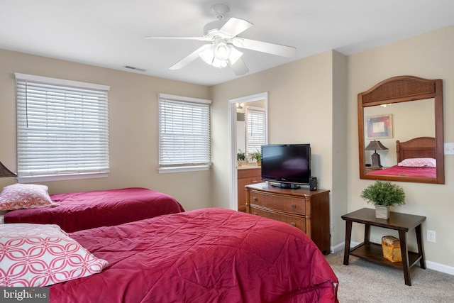 bedroom featuring connected bathroom, ceiling fan, and light carpet