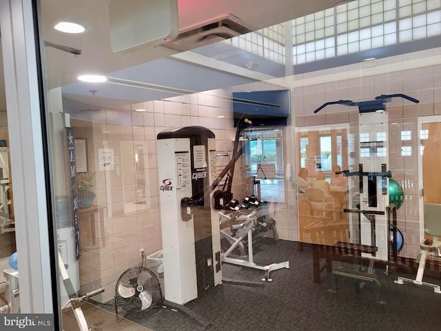 gym featuring plenty of natural light and tile walls