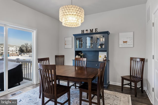 dining room featuring dark hardwood / wood-style floors and an inviting chandelier