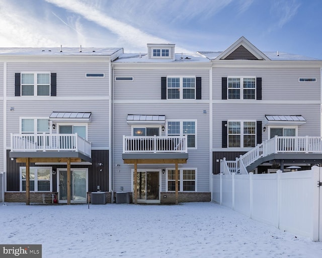 snow covered back of property featuring cooling unit