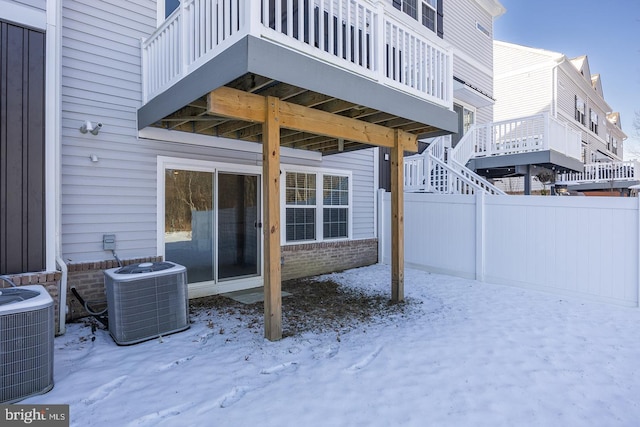 snow covered patio featuring central air condition unit