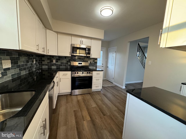 kitchen featuring sink, white cabinetry, dark hardwood / wood-style floors, stainless steel appliances, and backsplash