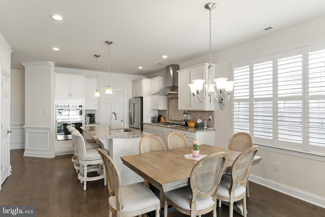 dining area with sink, a chandelier, and dark hardwood / wood-style floors