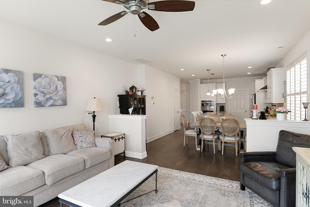 living room featuring ceiling fan with notable chandelier and dark hardwood / wood-style floors