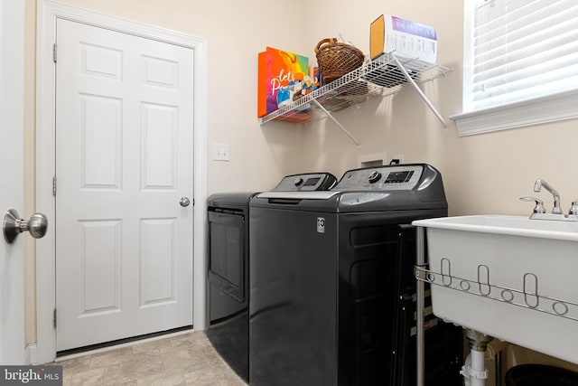 washroom with separate washer and dryer and sink