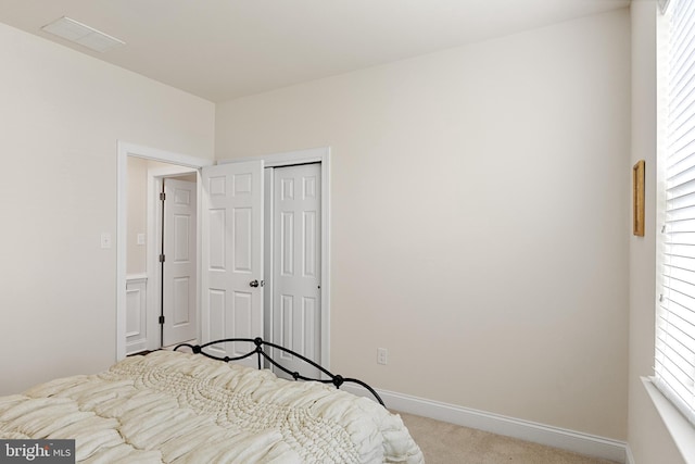 bedroom featuring light colored carpet and a closet