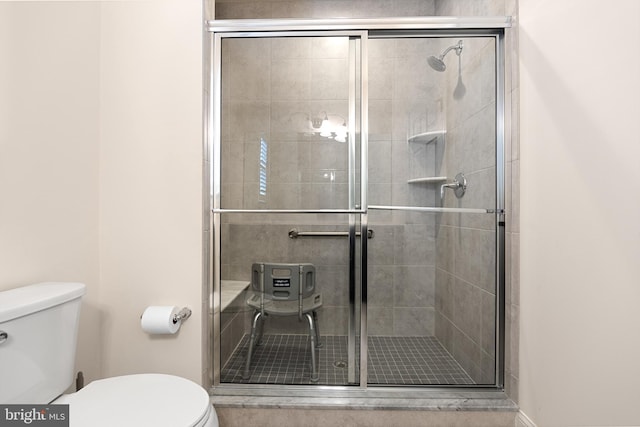 bathroom with toilet and a shower with shower door