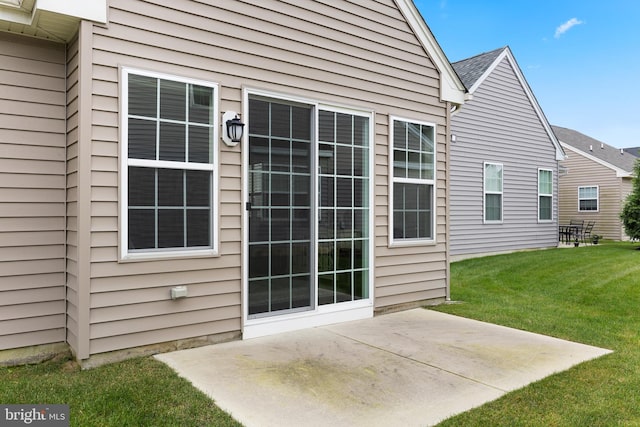 property entrance featuring a lawn and a patio