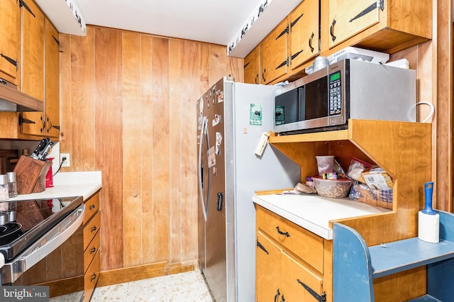 kitchen with appliances with stainless steel finishes, wooden walls, and custom exhaust hood