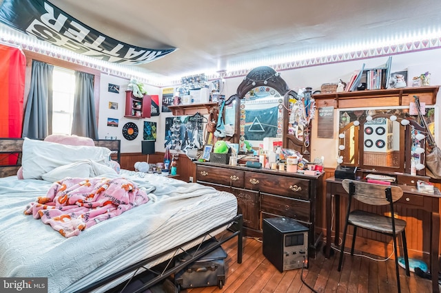 bedroom with wood-type flooring and wooden walls