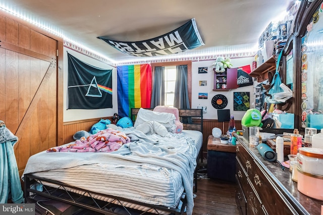 bedroom featuring wood-type flooring and wood walls