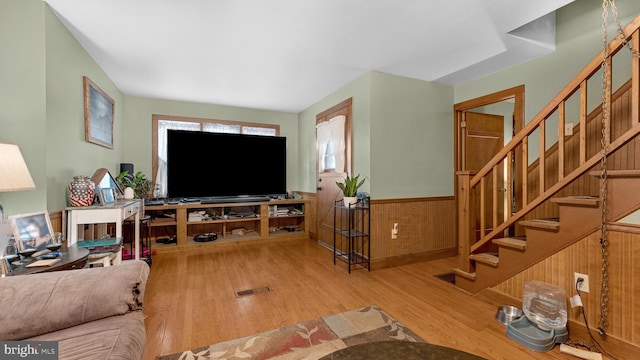 living room with hardwood / wood-style floors and wooden walls