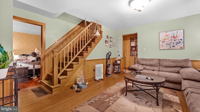 living room featuring wood walls, wood-type flooring, and radiator