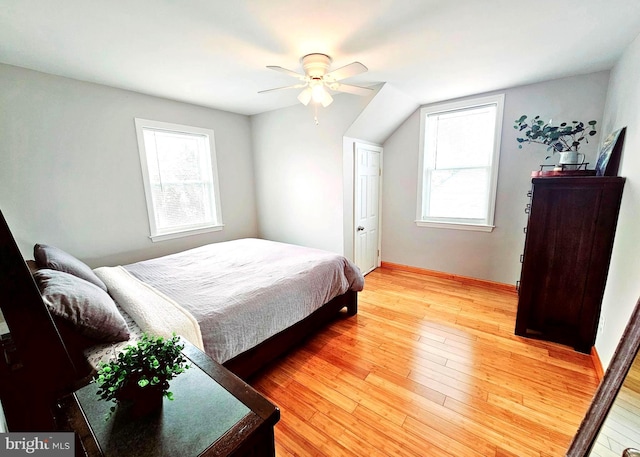 bedroom featuring ceiling fan, multiple windows, and light wood-type flooring