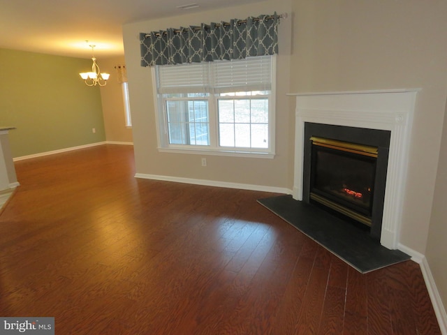 unfurnished living room featuring dark hardwood / wood-style flooring and an inviting chandelier