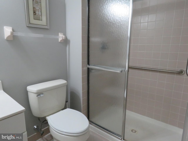 bathroom featuring vanity, toilet, and an enclosed shower