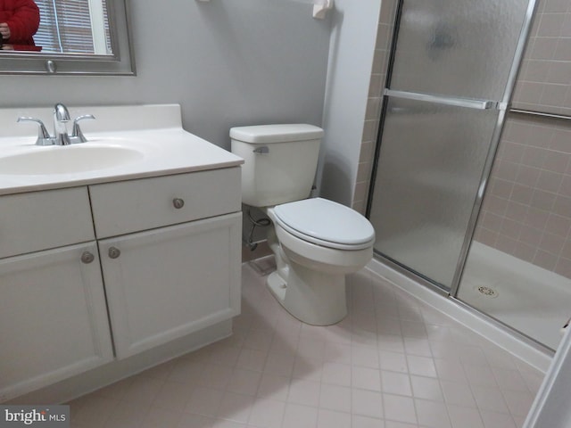 bathroom featuring tile patterned floors, a shower with door, vanity, and toilet