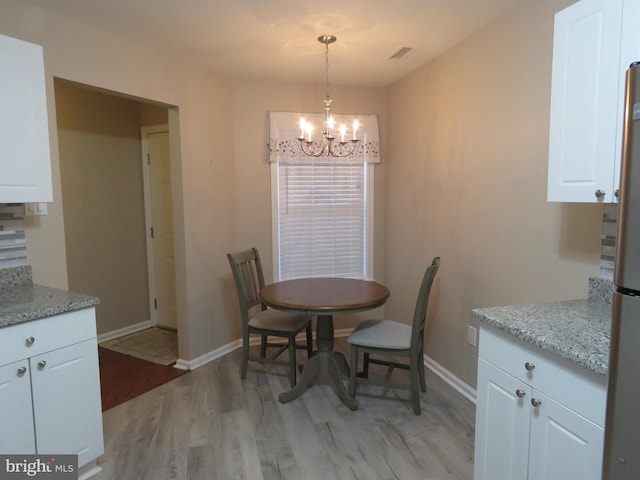 dining room with a notable chandelier and light hardwood / wood-style flooring