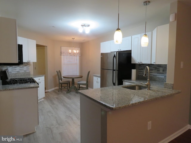 kitchen with sink, stainless steel fridge, tasteful backsplash, white cabinetry, and kitchen peninsula