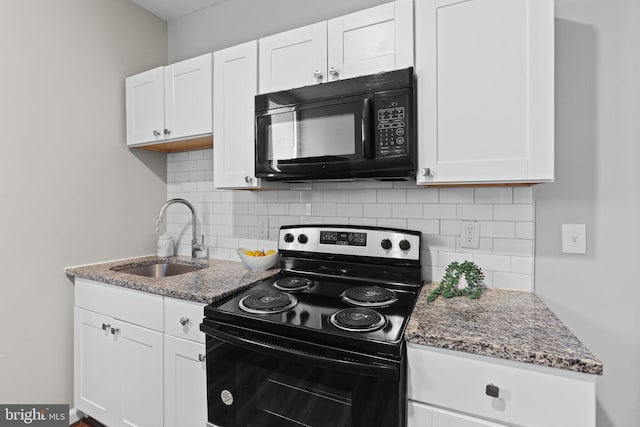 kitchen featuring sink, white cabinets, dark stone counters, and black appliances