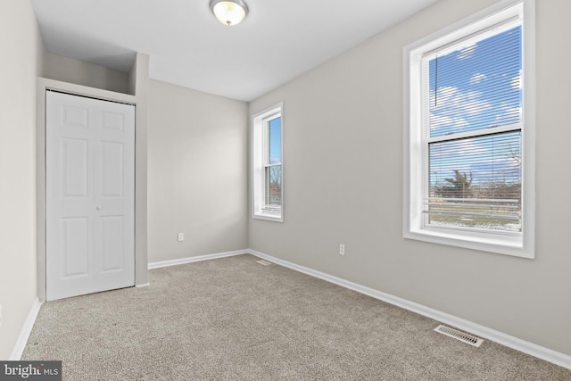 unfurnished bedroom featuring a closet and light carpet