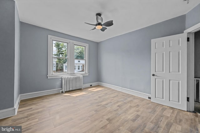 spare room featuring ceiling fan, light hardwood / wood-style floors, and radiator