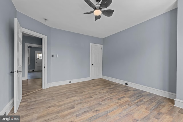 empty room with ceiling fan and light hardwood / wood-style flooring