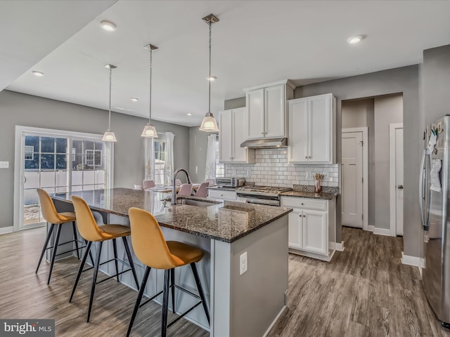 kitchen featuring appliances with stainless steel finishes, sink, white cabinets, and a kitchen island with sink